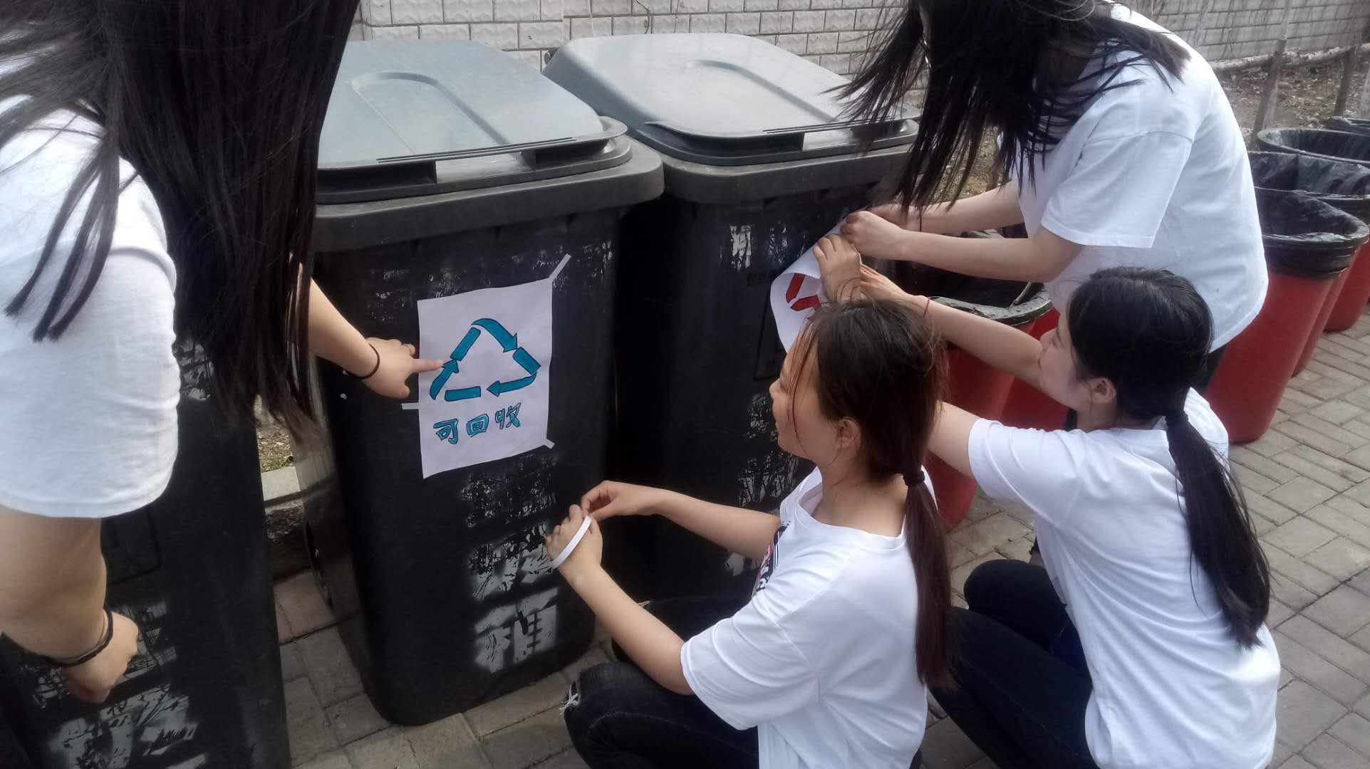 志愿者给垃圾箱贴分类标识.jpg